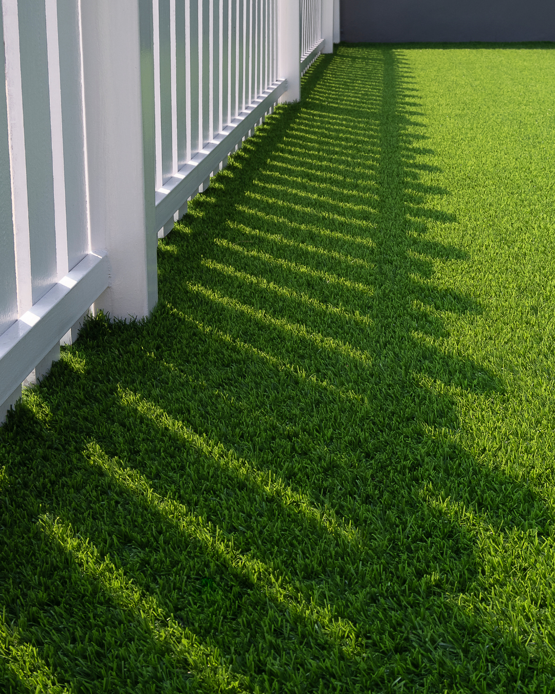Artificial turf along white fence